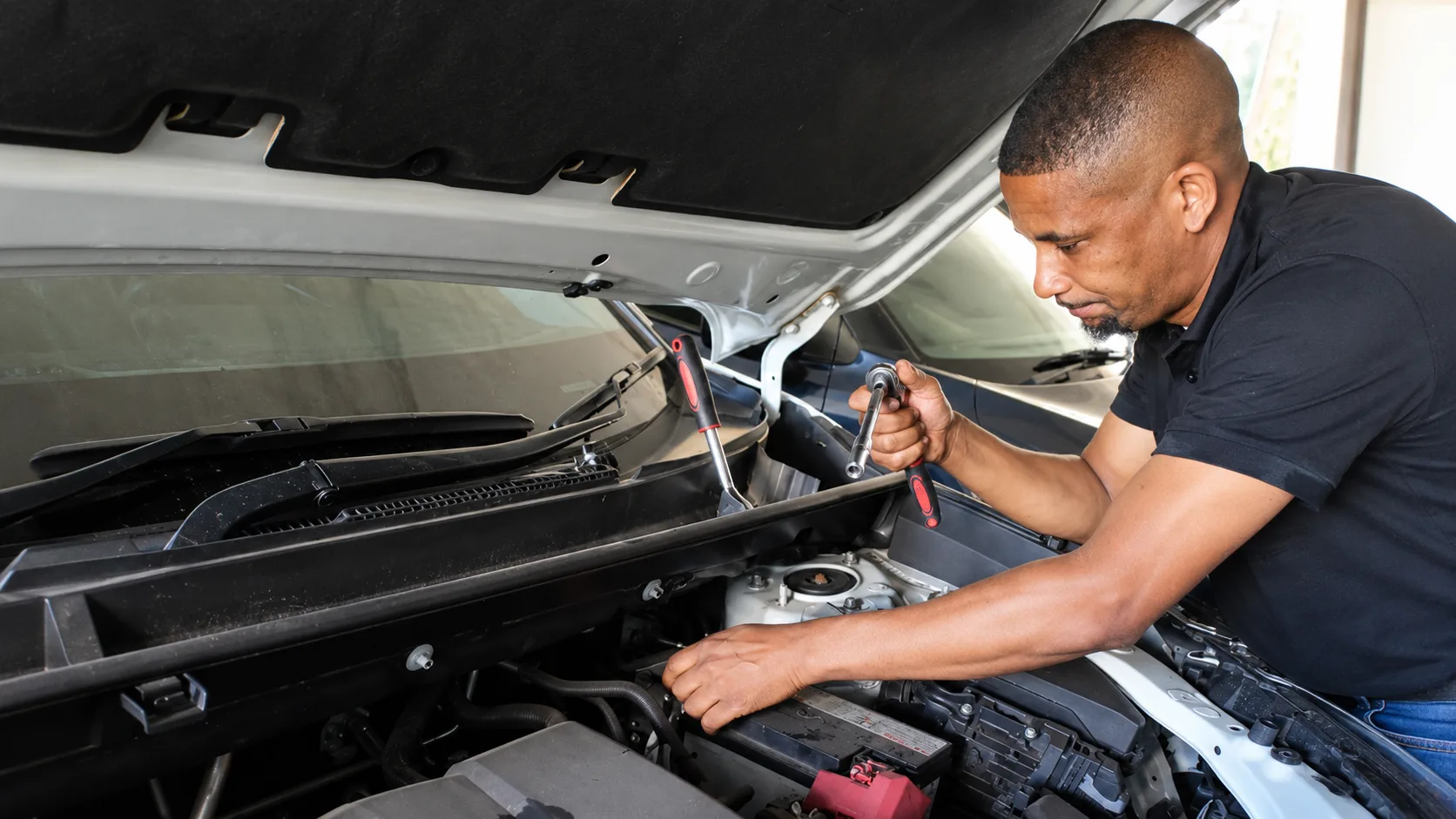 Close-up of a technician inspecting a car battery